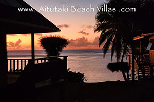 sunset over lagoon through palm trees from the veranda